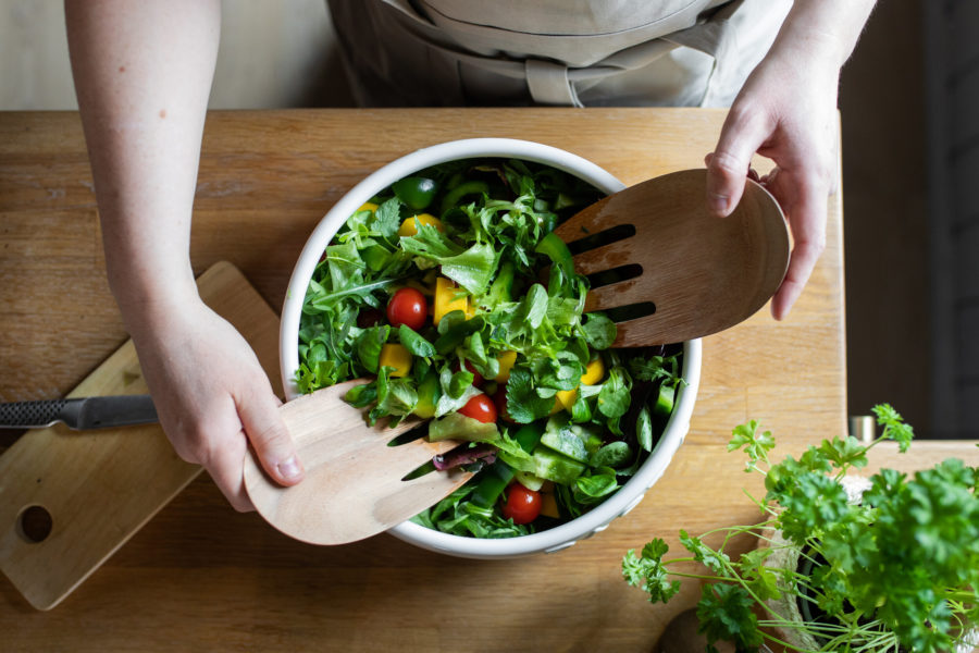Mikse frisk salat i stor bolle med salatbestikk